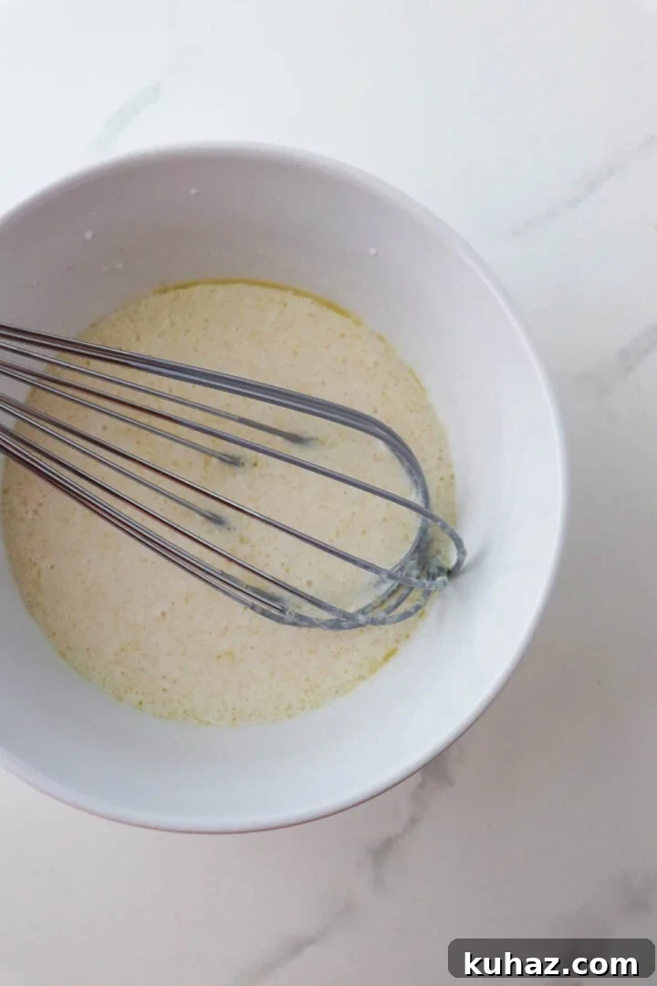 Homemade Buttermilk Bread Recipe: Soft, Tender Loaf 5 Liquid ingredient for Soft and Tender Buttermilk Bread in a bowl with a whisk.