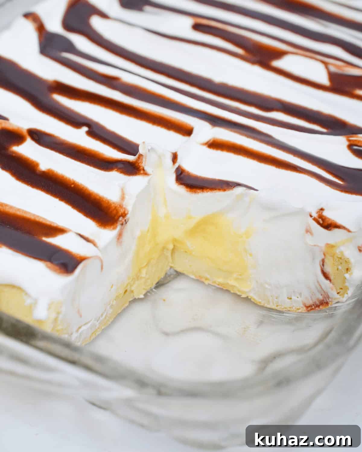 Cream Puff Cake Recipe with Vanilla Custard Filling 3 A tray of the dessert with a square taken out.