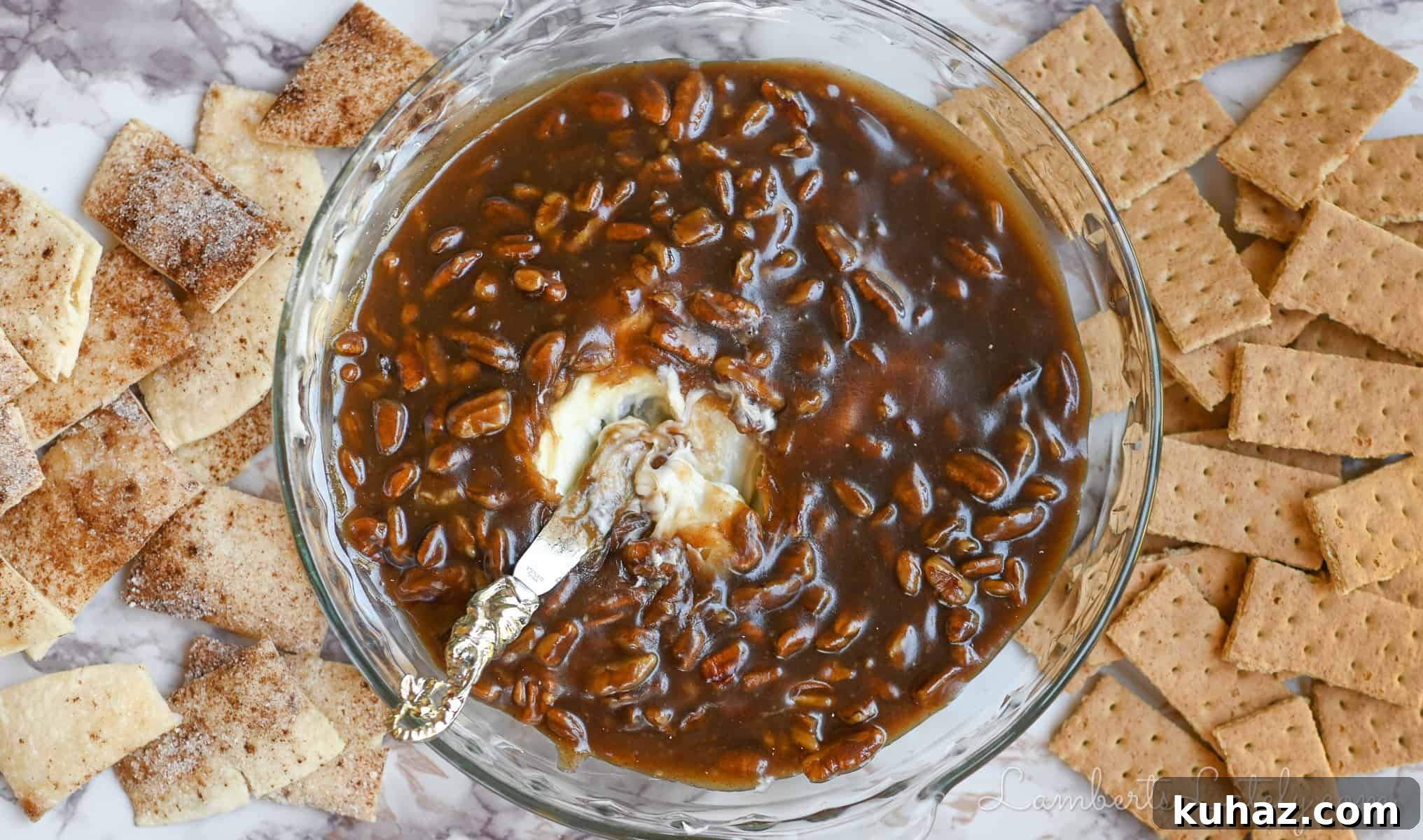 No Bake Pecan Pie Dip with Cream Cheese 7 pecan pie dip in a pie dish, with a knife, surrounded by pie crust and graham cracker dippers.