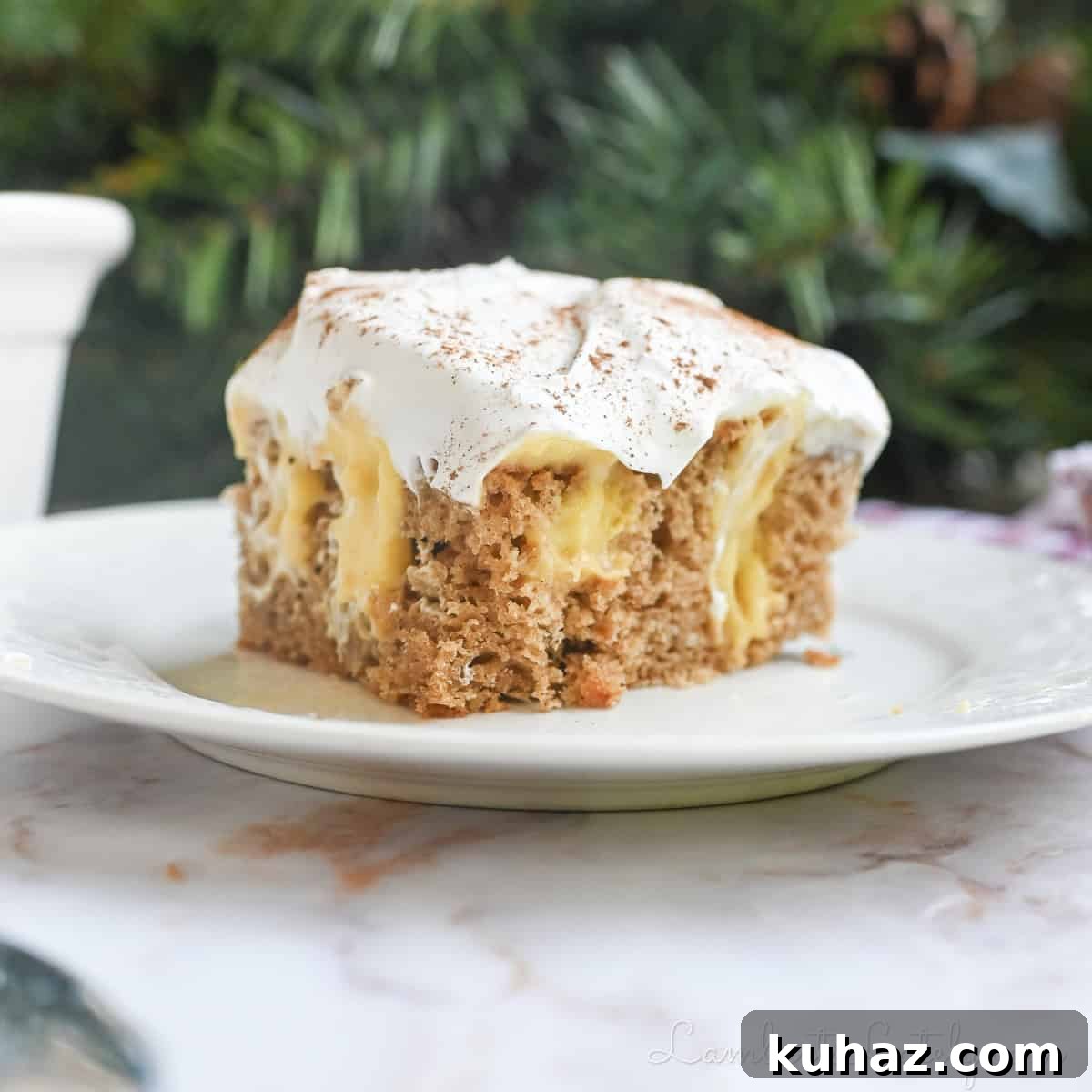 No Bake Pecan Pie Dip with Cream Cheese 8 piece of eggnog poke cake on a plate in front of greenery and a baking pan.