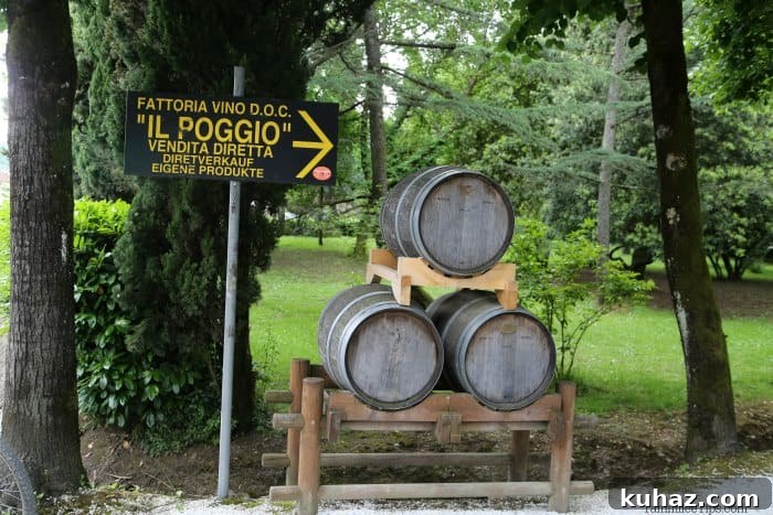Tuscany Wine Tasting Shore Excursion from Cruise Ports 4 Il Poggio sign next to wine barrels stacked on top of each other