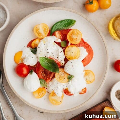 A burrata caprese salad on a small plate.
