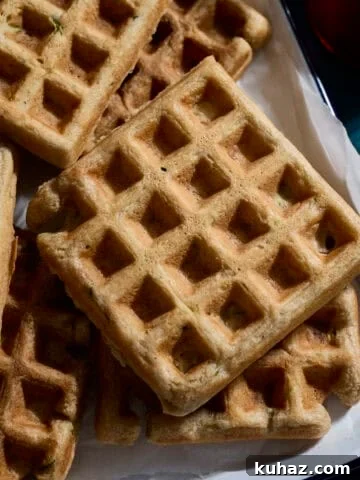 A stack of Sourdough Zucchini Waffles on a white tray.