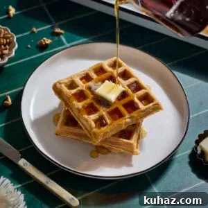 Crispy Sourdough Sweet Potato Waffles 16 Syrup pouring onto a stack of Sourdough Sweet Potato Waffles.
