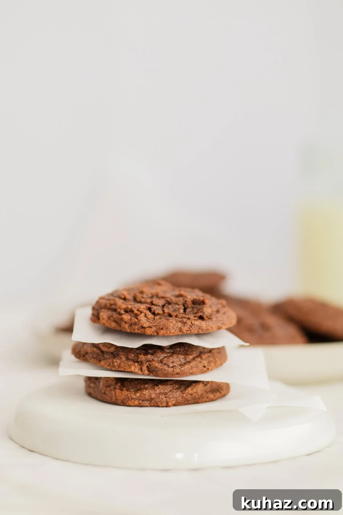 Chewy 4-Ingredient Brownie Mix Cookies 11 brownie cookies separated by parchment paper on a plate