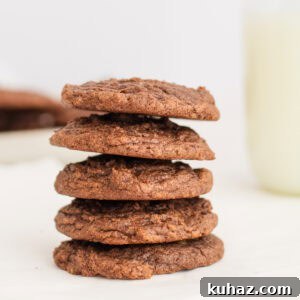 brownie mix cookies stacked 5 high with a glass of milk in background