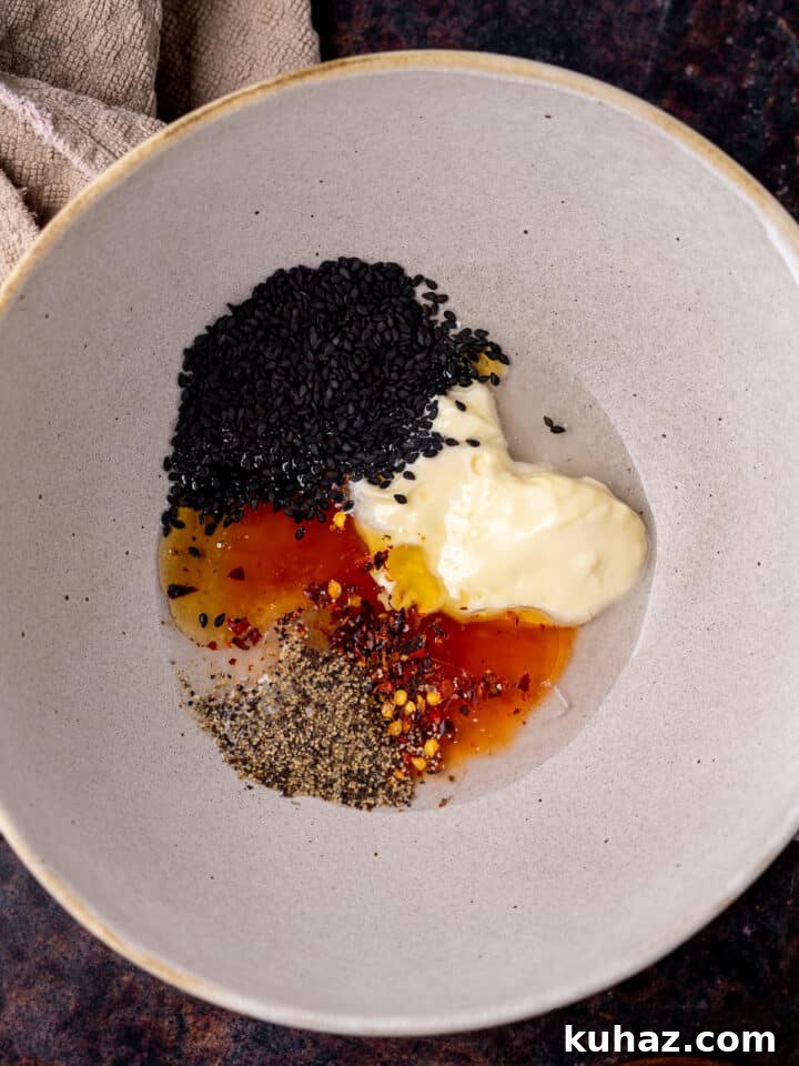 mayo, black sesame seeds, sweet chili sauce, vinegar, salt, pepper and red chile flakes in bowl