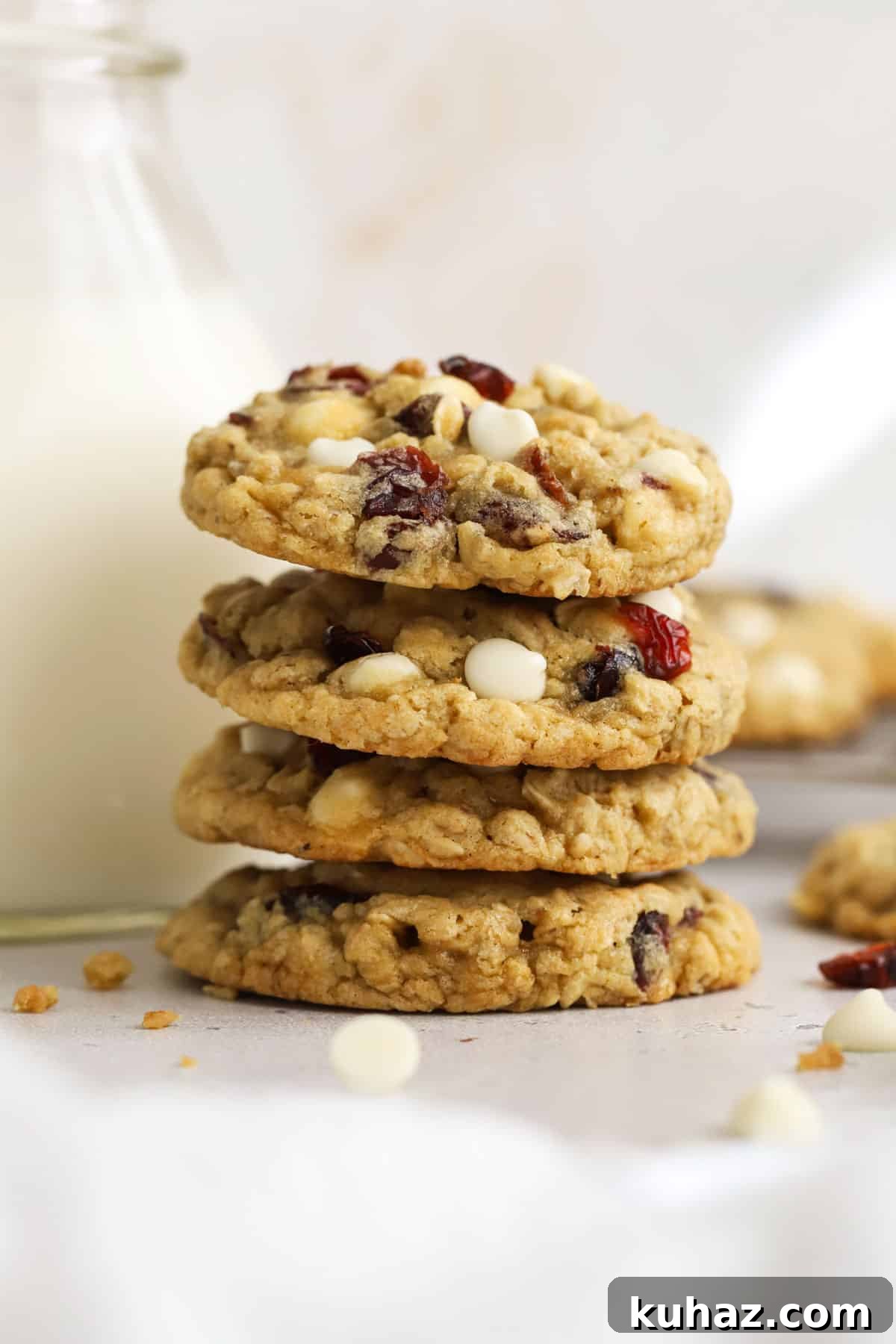 Gluten Free Cranberry White Chocolate Oatmeal Cookies 12 gluten-free cranberry white chocolate oatmeal cookies stacked next to a jar of milk