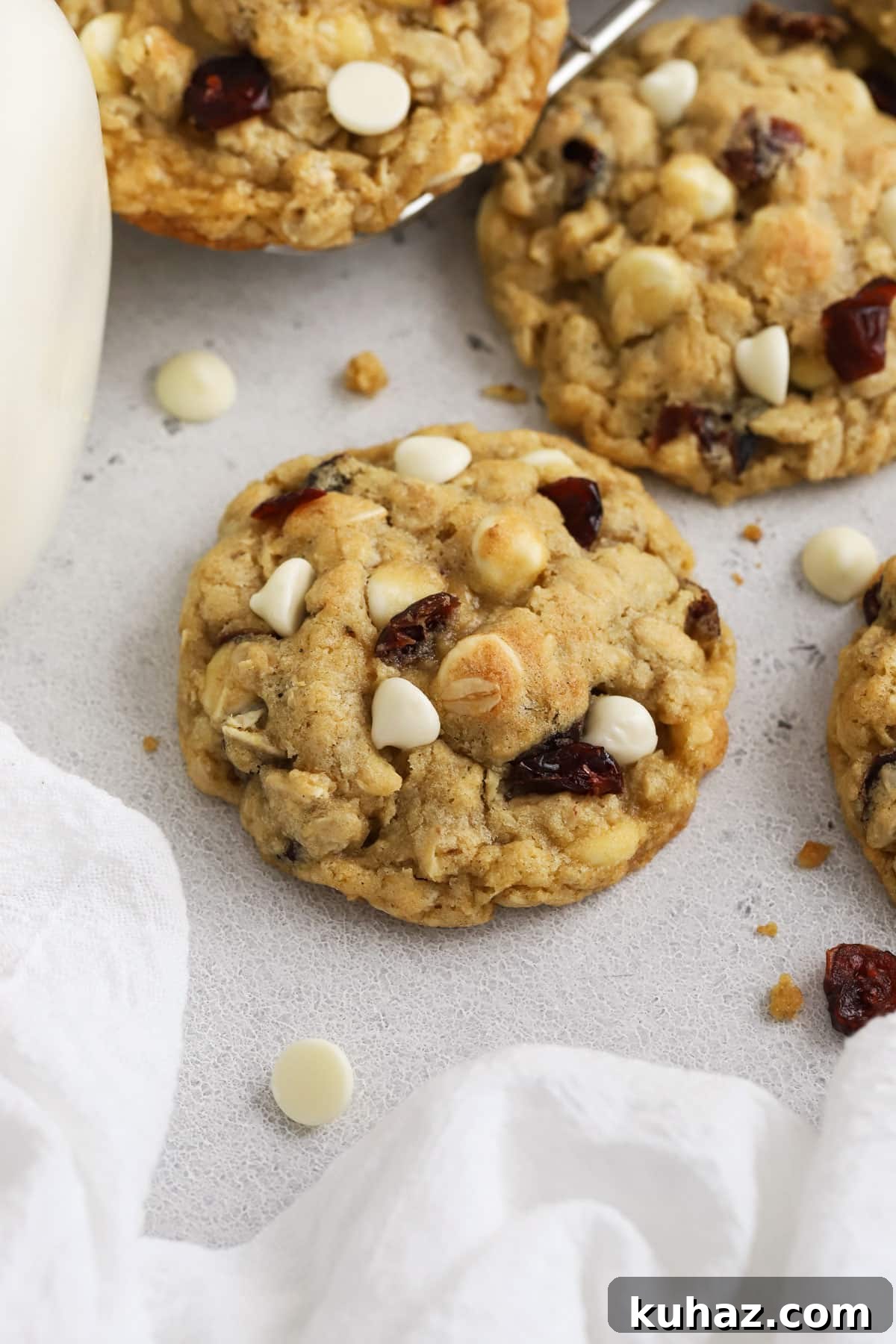 Gluten Free Cranberry White Chocolate Oatmeal Cookies 6 gluten-free cranberry white chocolate chip oatmeal cookies next to a jar of milk