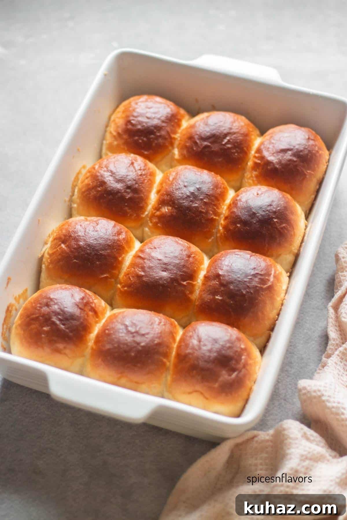 Fluffy Homemade Bread Machine Dinner Rolls Recipe 2 baked dinner rolls in a ceramic baking pan