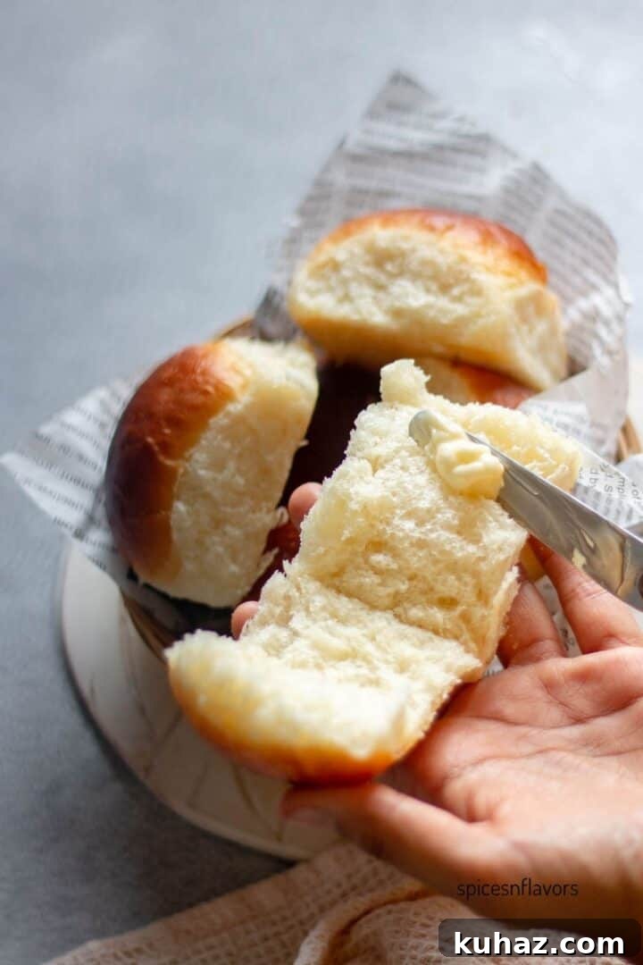 Fluffy Homemade Bread Machine Dinner Rolls Recipe 9 applying butter on dinner rolls