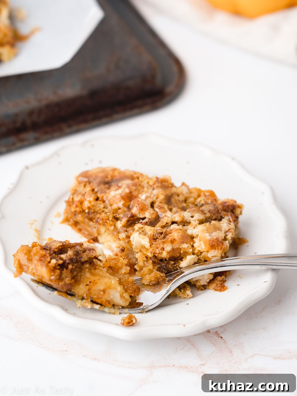Quick Pumpkin Pie Cake with Cake Mix 3 Slice of pumpkin pie dump cake on a white plate with a fork.