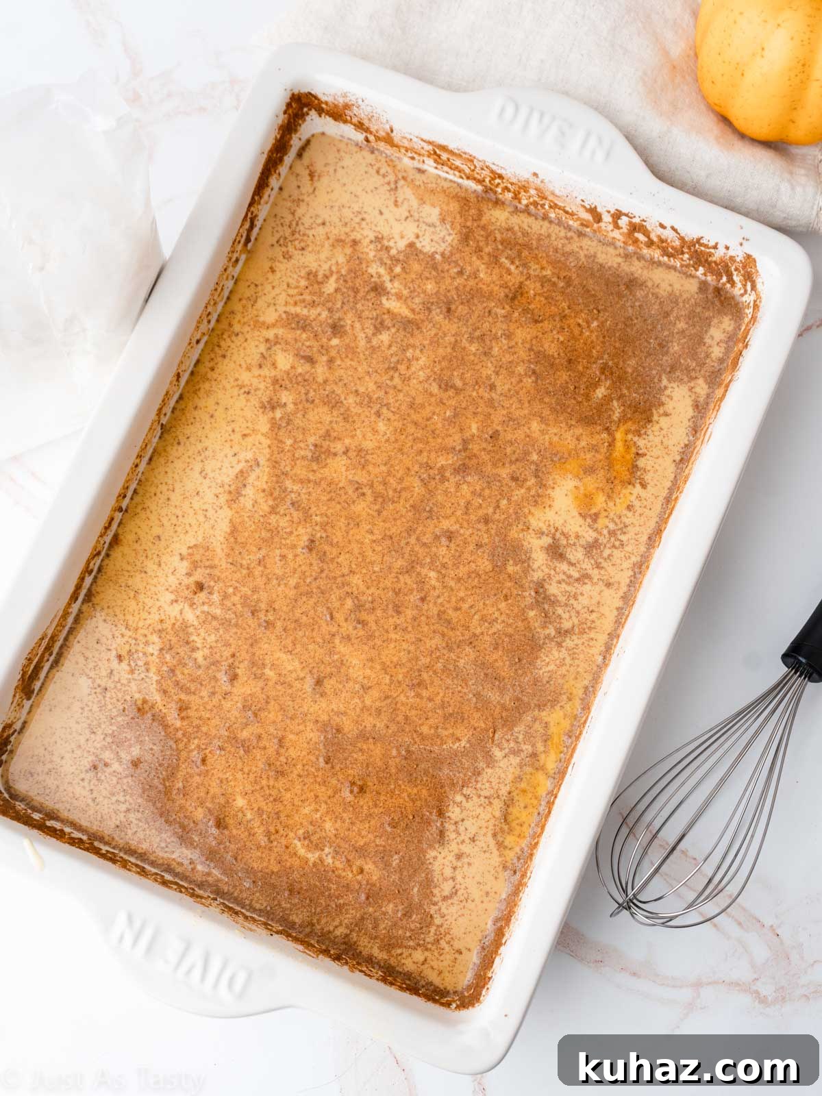 Quick Pumpkin Pie Cake with Cake Mix 4 Pumpkin pie cake process shot showing wet ingredients in a cake pan.
