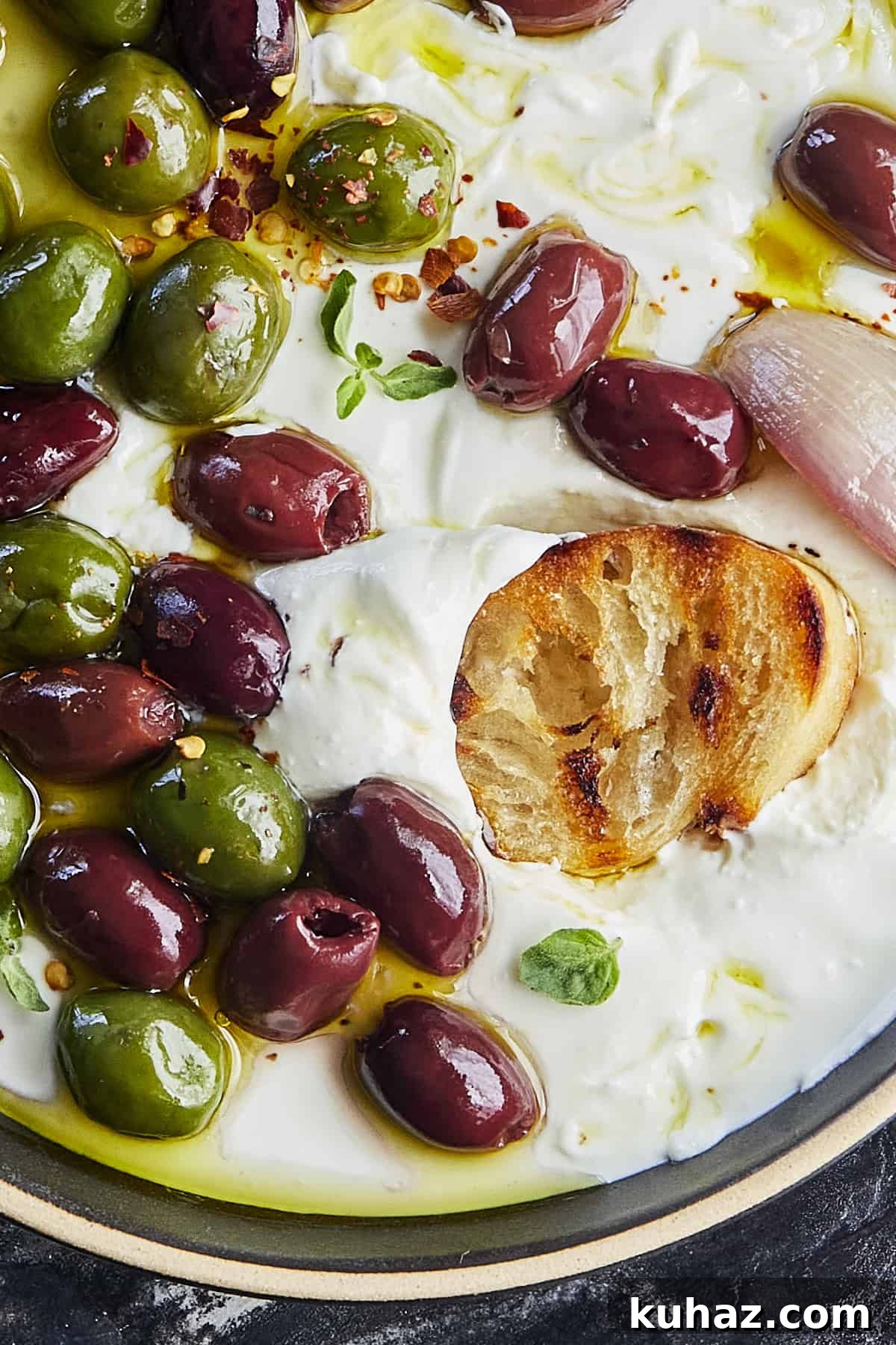 Whipped Feta Dip with Roasted Olives 3 Whipped feta with roasted olives on a serving plate
