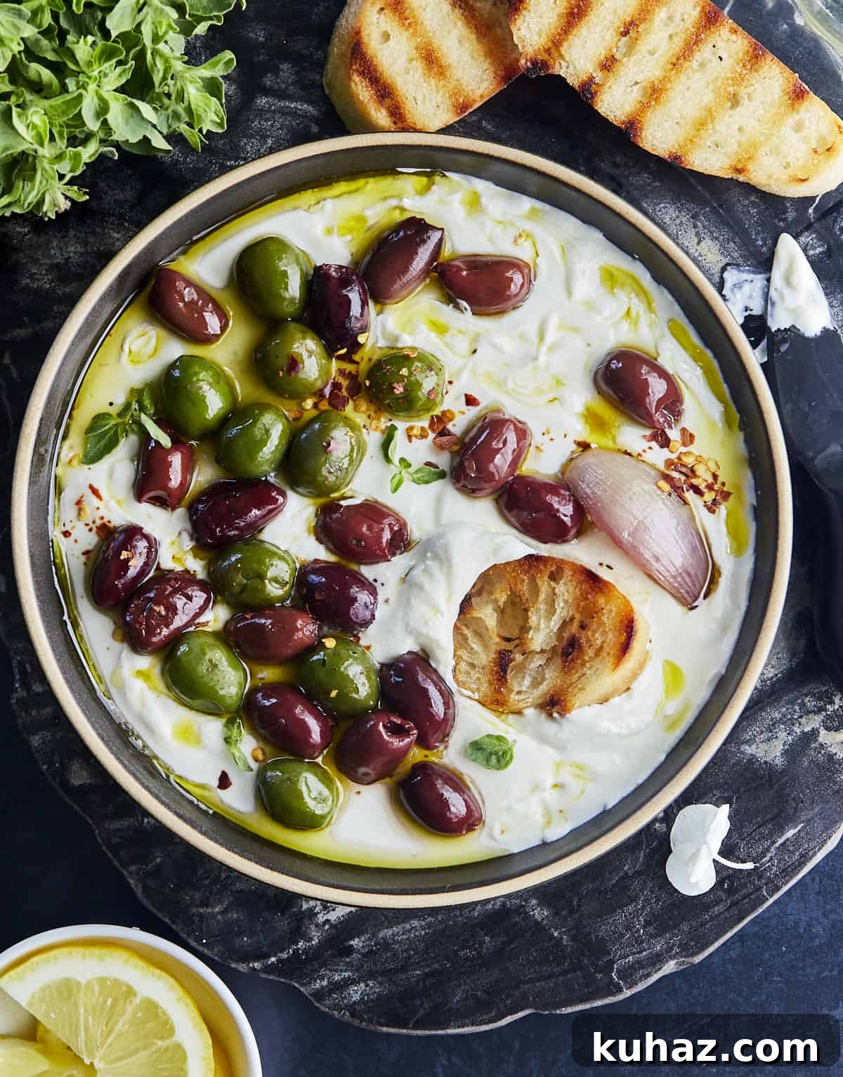 Whipped Feta Dip with Roasted Olives 4 Close-up of whipped feta spooned onto bread