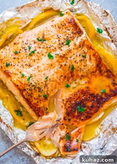 Grilled salmon fillet with herbs and lemon butter sauce in foil.