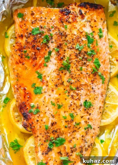 Baked salmon fillet with lemon and herbs on foil.