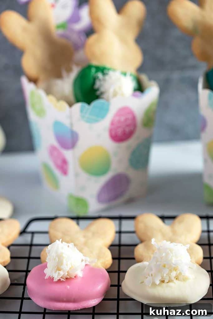Easter Bunny Cookies with Fluffy Marshmallow Tails 18 two bunny shortbread cookies over a cooling rack next to a colorful box filled with cookies