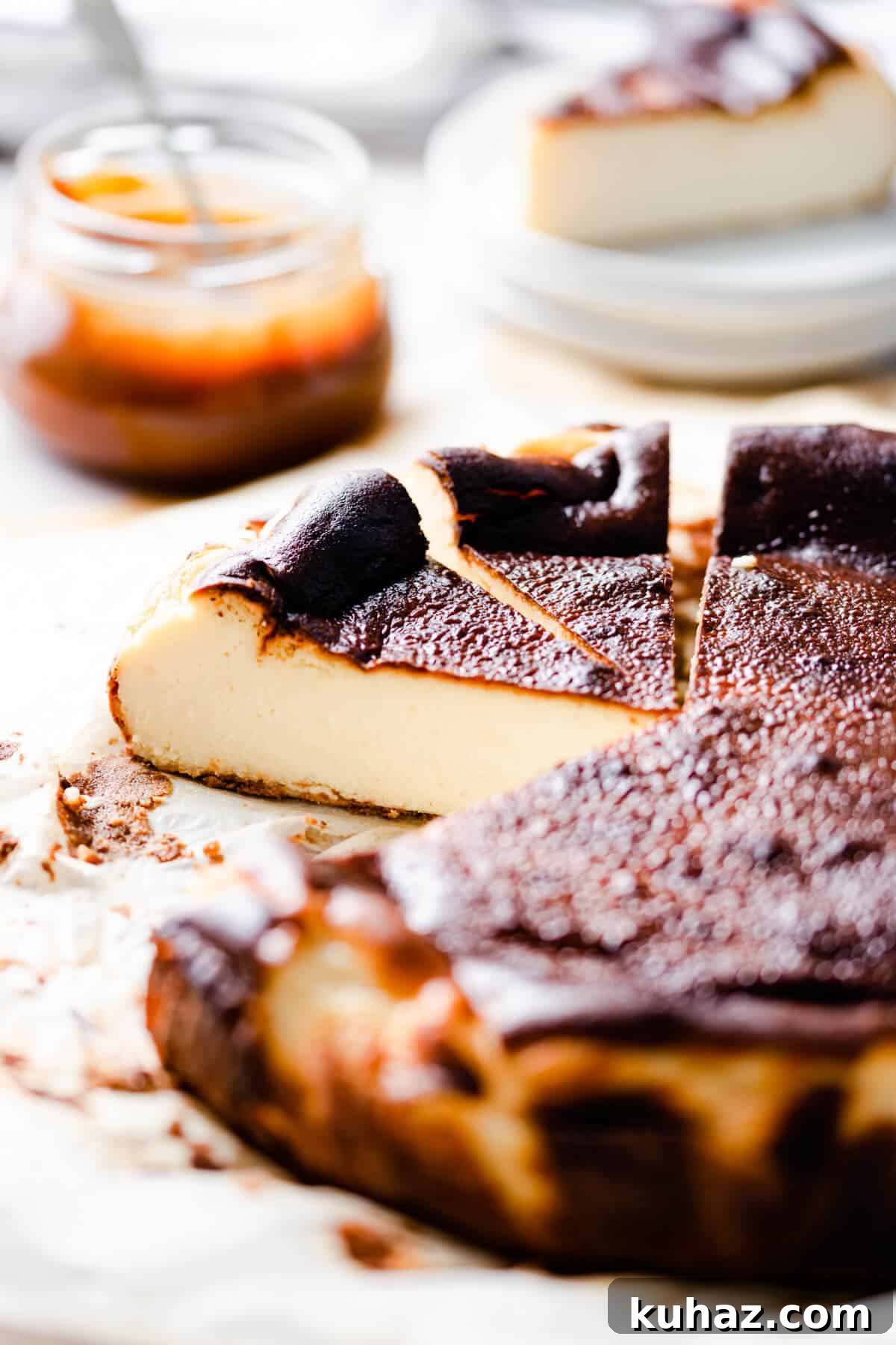 Basque Burnt Cheesecake Recipe — Silky, Caramelized Top 2 45 degree side shot of burnt basque cheesecake with couple of slices cut out