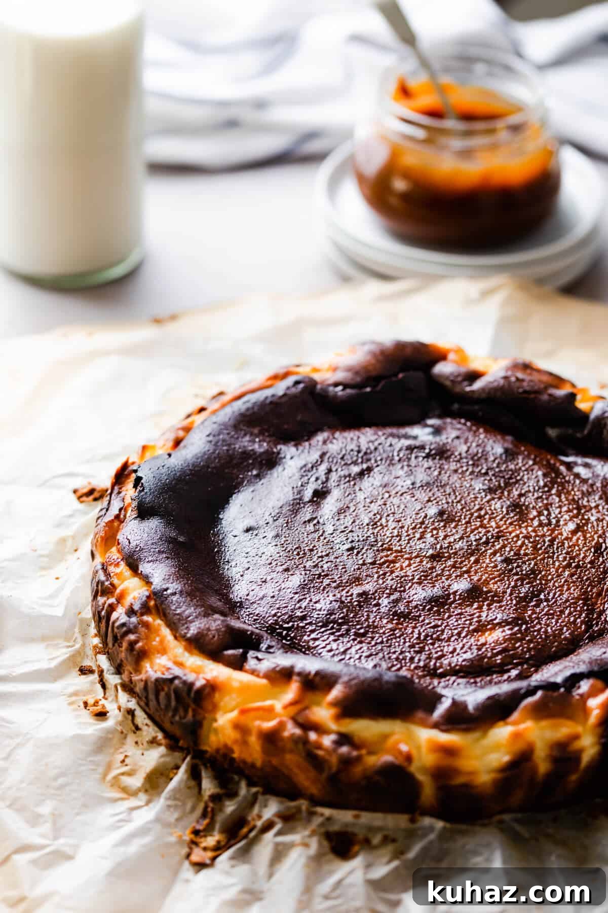 Basque Burnt Cheesecake Recipe — Silky, Caramelized Top 8 side angle of basque cheesecake on some baking paper
