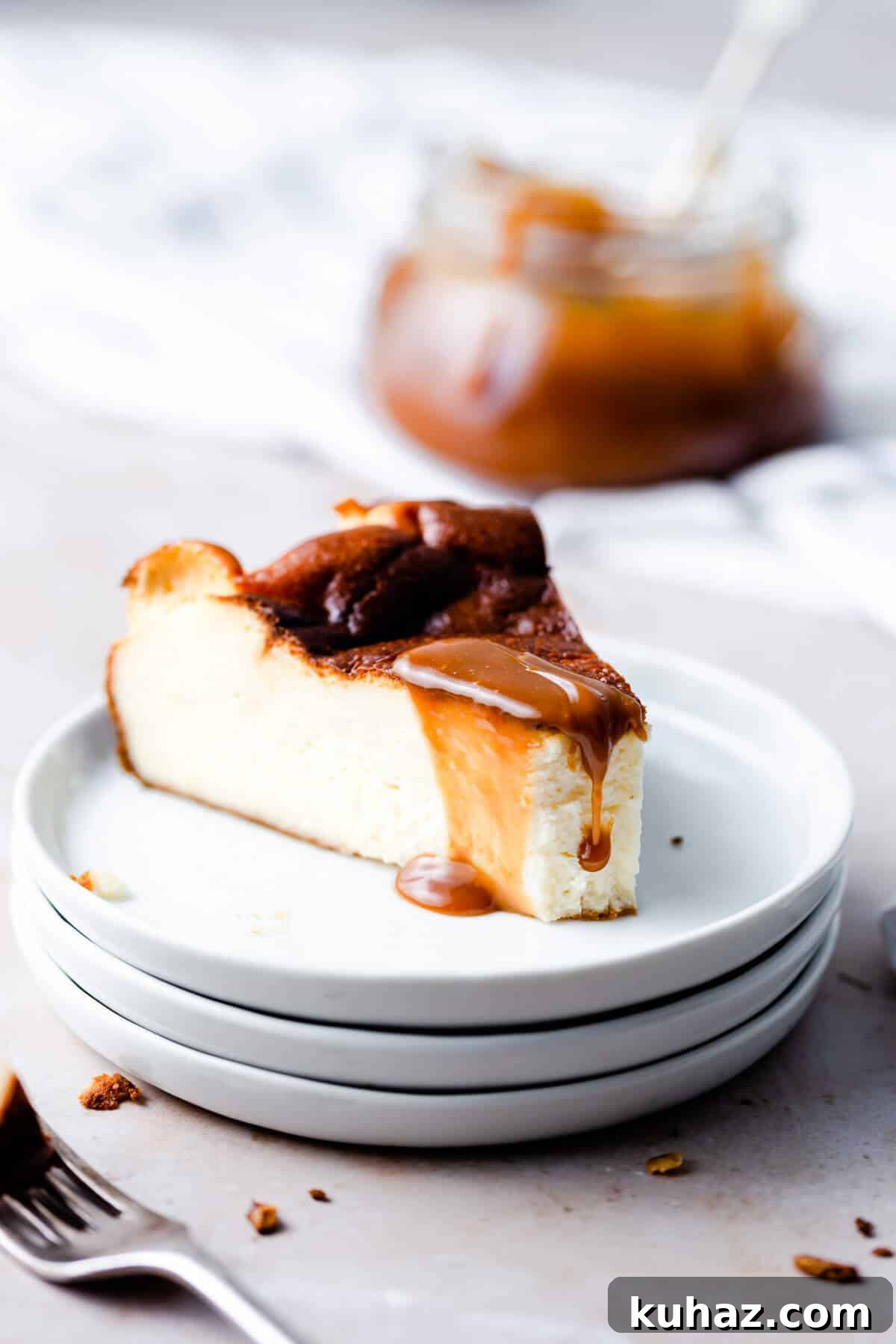 Basque Burnt Cheesecake Recipe — Silky, Caramelized Top 9 side angle close up at a slice of burnt cheesecake with a bite missing and some caramel sauce dripping from top