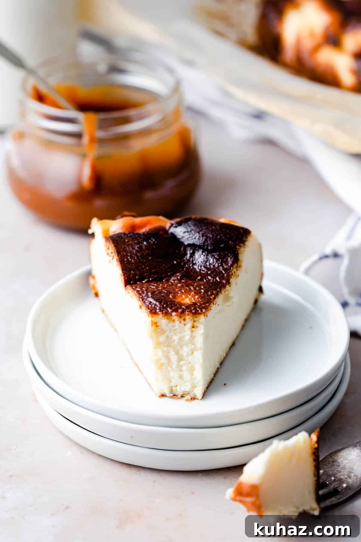 Basque Burnt Cheesecake Recipe — Silky, Caramelized Top 10 straight ahead close up of a slice of cheesecake with bite missing, revealing the creamy texture