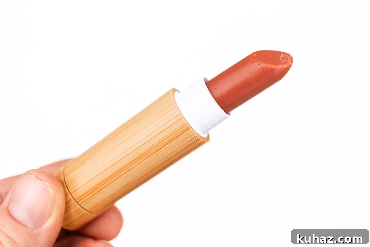 Holding a tube of homemade lipstick with a white background.