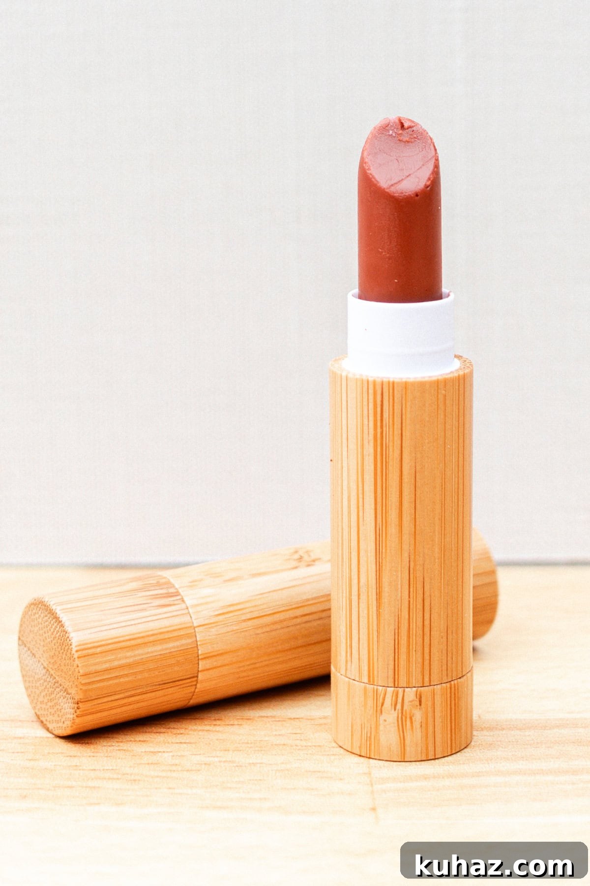 A tube of homemade lipstick on a wooden countertop.