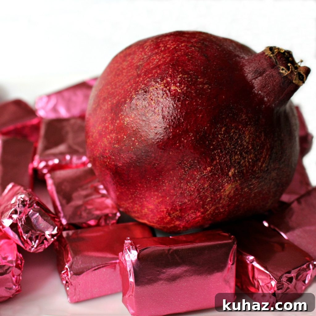 10 Traditional Chinese New Year Treats to Try 7 A pomegranate surrounded by Pomegranate Caramels wrapped in pink foil.