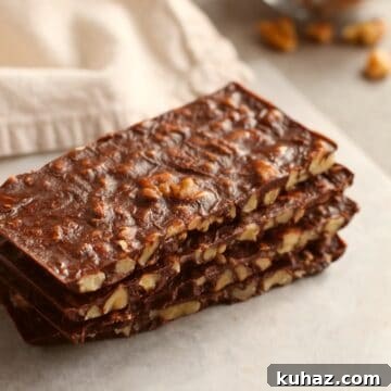 rectangular shaped sliced bars stacked on top of each other with beige napkin and walnut pieces in background