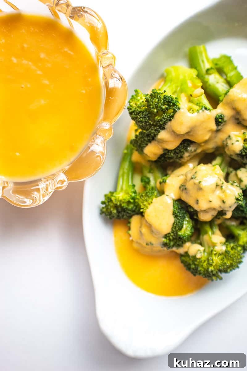 Perfect Mornay Sauce Recipe for Creamy Cheese Sauce 2 White bowl of broccoli with cheese sauce on it; side of cheese sauce