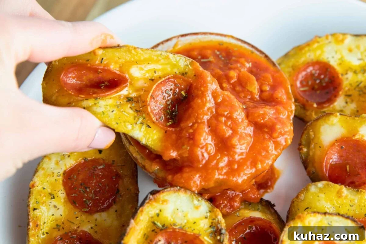 Pizza-Style Potato Skins Recipe with Pepperoni & Mozzarella 4 deliciously cheesy pizza potato skin shown dipped in pizza sauce.
