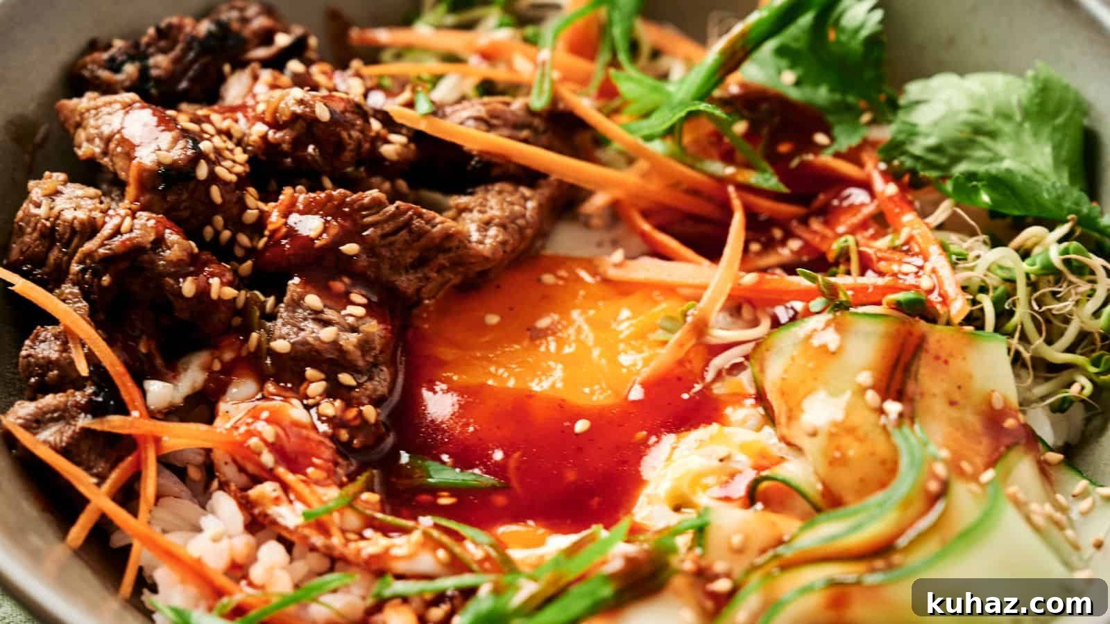 19 Asian Recipes That Fed My Family for $20 13 A bowl of bibimbap with sliced beef, egg yolk, carrots, cucumber, greens, and bean sprouts, topped with sesame seeds and red sauce.