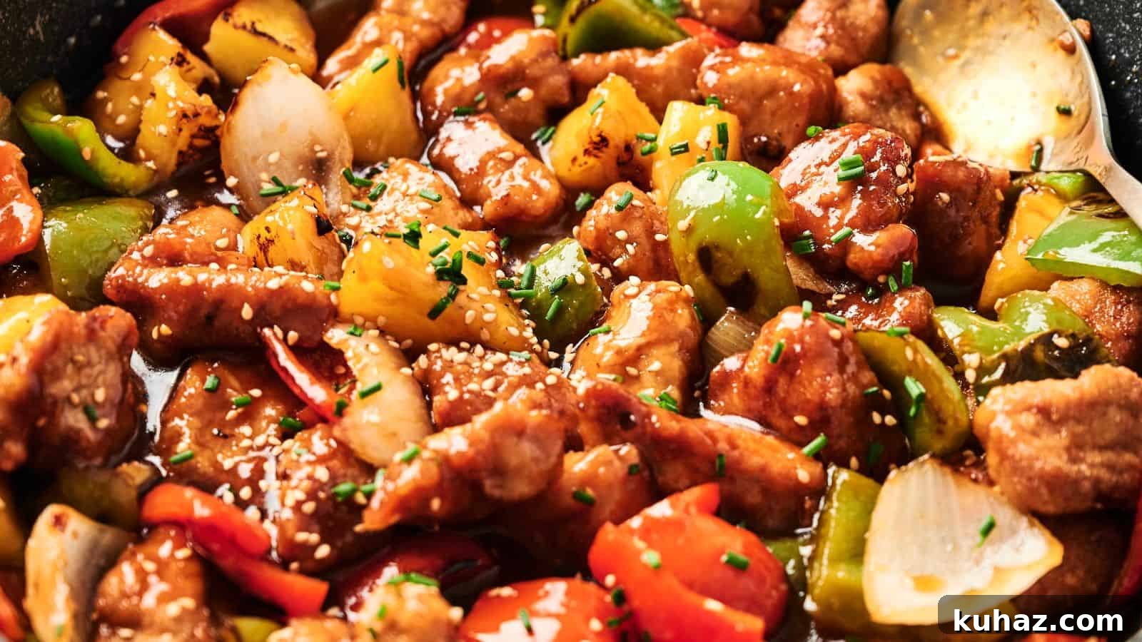 19 Asian Recipes That Fed My Family for $20 19 Close-up of sweet and sour pork with chunks of bell peppers, onions, and pineapple, garnished with sesame seeds and chives.