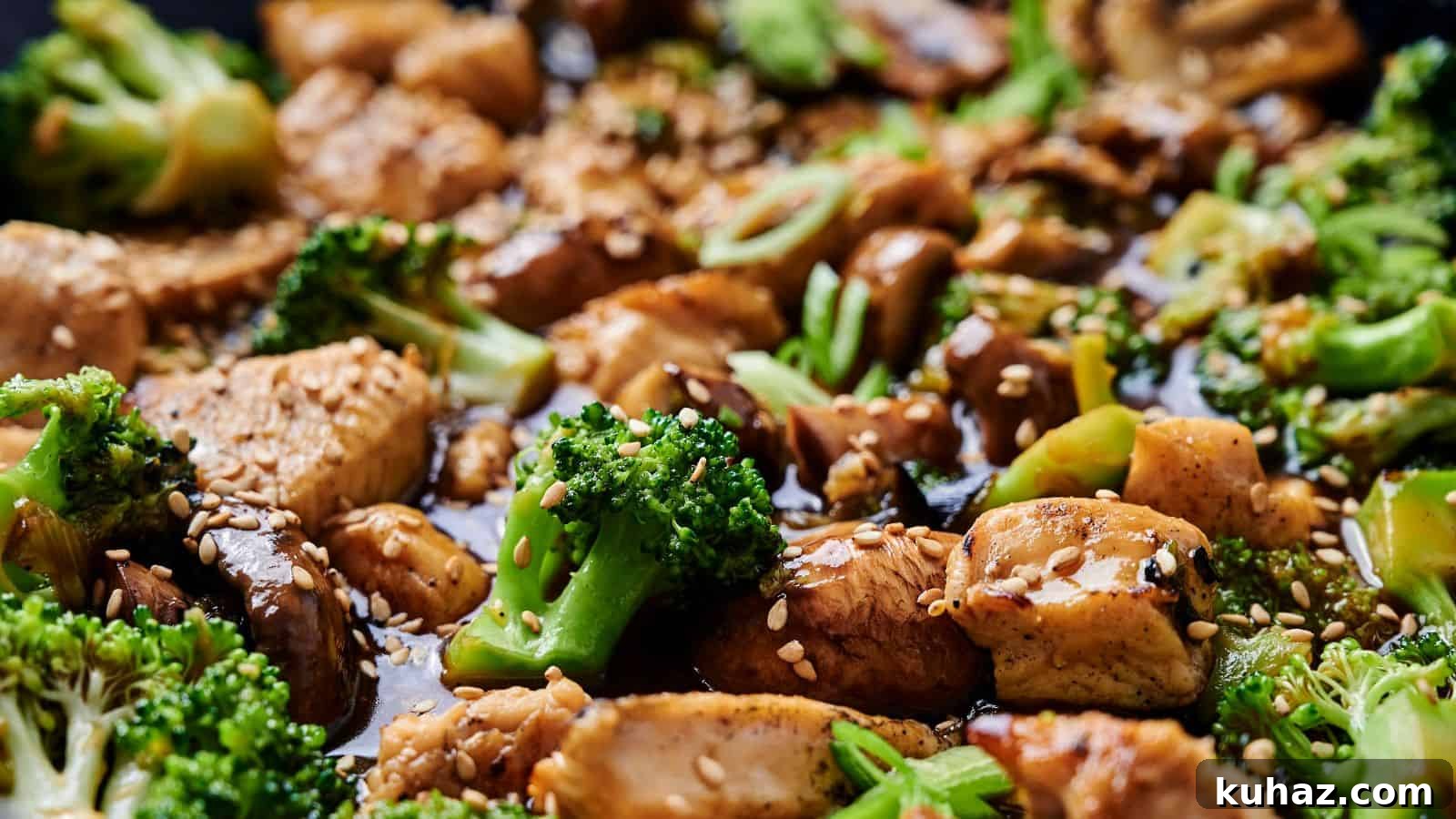 19 Asian Recipes That Fed My Family for $20 20 Close-up of a stir-fry dish with chicken, broccoli, mushrooms, and sesame seeds, coated in a soy-based sauce.
