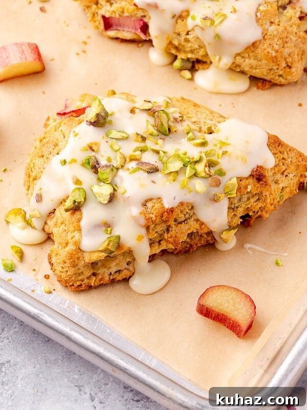Rhubarb Scones with Orange and Pistachios on parchment paper lined baking sheet.