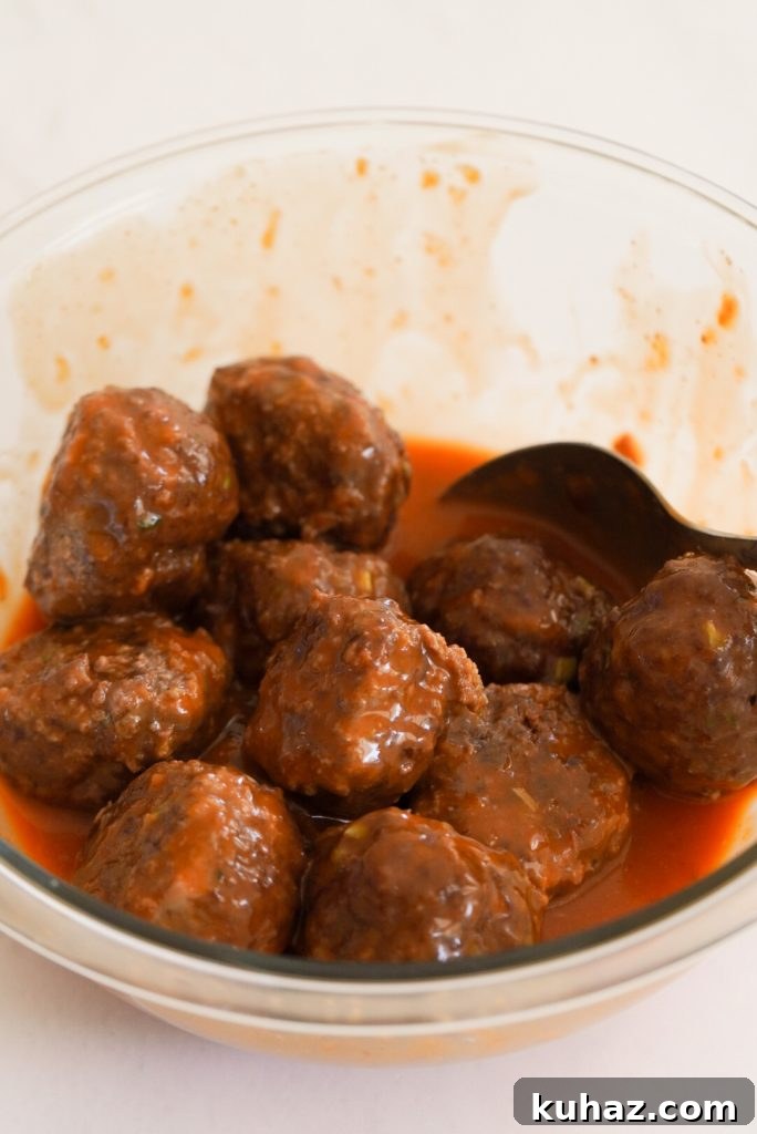 Spicy Firecracker Meatballs Recipe with Sweet Chili Glaze 11 process shot - baked beef meatballs tossed with firecracker sauce.