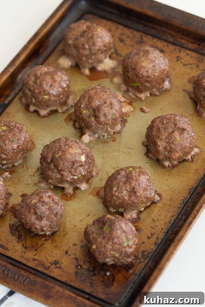 Spicy Firecracker Meatballs Recipe with Sweet Chili Glaze 9 process shot - firecracker meatballs on a baking sheet after baking.