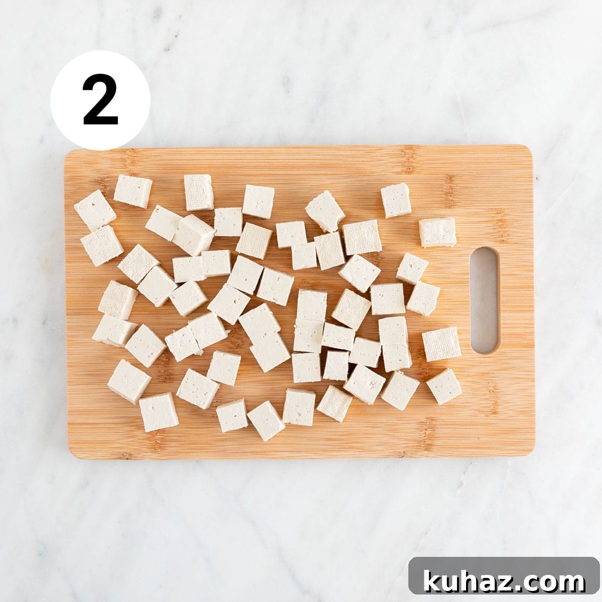 Homemade Vegan Feta Cheese Recipe 5 Tofu cubes on wooden cutting board.