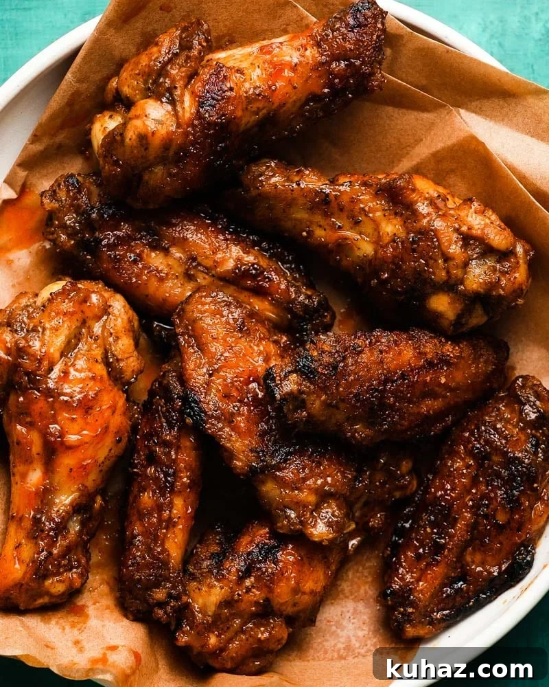 14 Crowd-Pleasing Game Day Appetizers 2 Grilled chicken wings with Old Bay brown butter glaze on parchment paper.