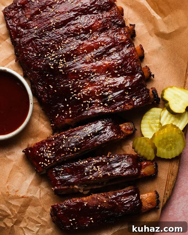 14 Crowd-Pleasing Game Day Appetizers 12 Barbecue ribs with sesame seeds, sauce, and pickles on brown parchment paper.
