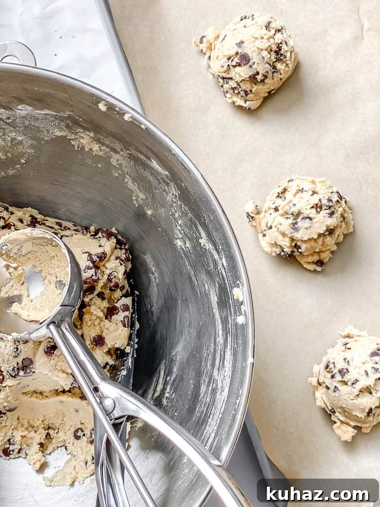 Loaded Kitchen Sink Cookies Recipe with Chocolate, Oats & Nuts 8 process shot showing adding cookies to baking sheet