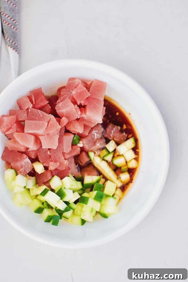 Ahi Tuna Tower with Avocado and Mango 8 Tuna, cucumber, and poke marinade in a bowl