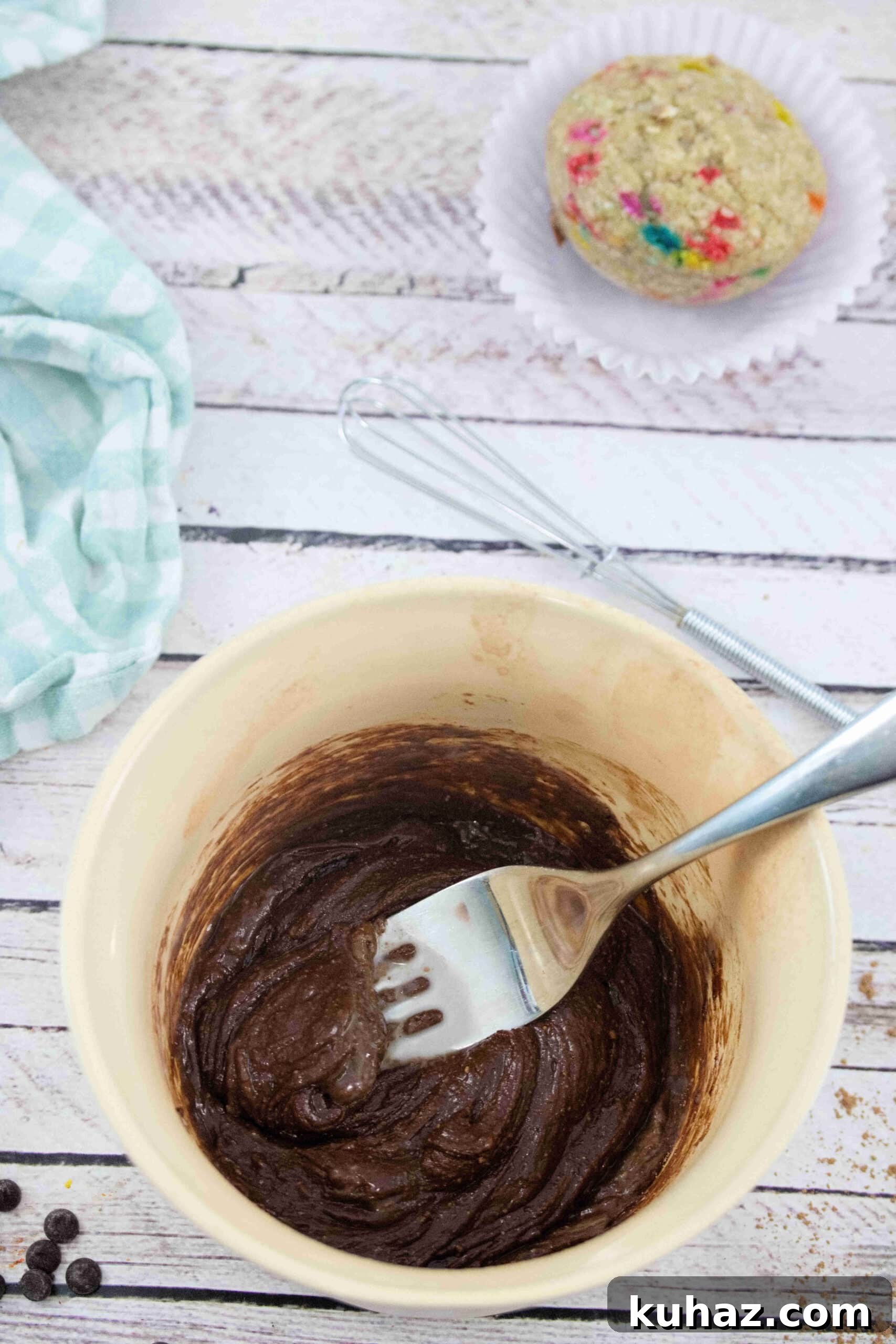 Bowl with finished chocolate frosting and a fork.