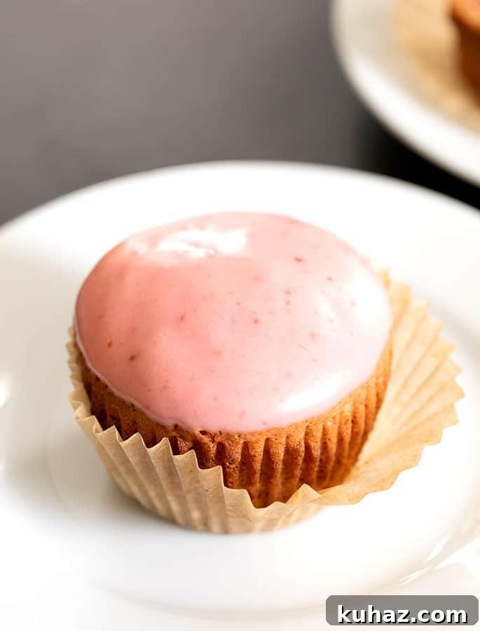 Gluten Free Strawberry Cupcakes with Fresh Strawberry Frosting 2 Strawberry cupcake on a plate with the liner peeling off