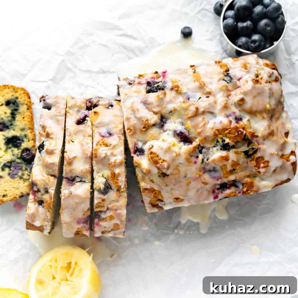 Overhead image of sliced bread on parchment paper. Lemon and blueberries around it.