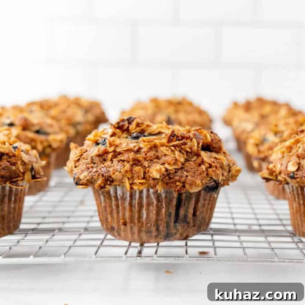 Blueberry muffins on a cooling rack with a subway tile background.