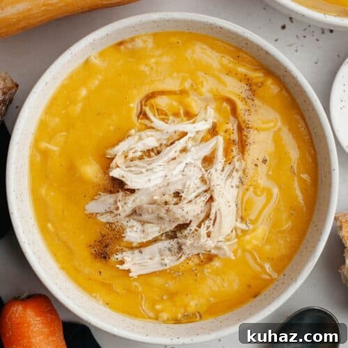 A white bowl with butternut squash chicken soup.