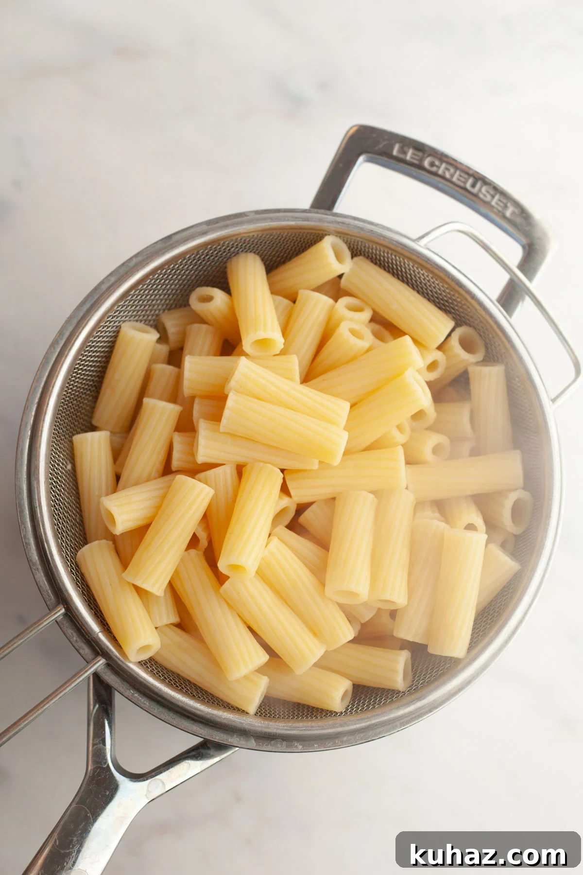 Creamy Baked Pasta with Vodka-Style Sauce, Alcohol-Free 4 Cooked pasta in a sieve.