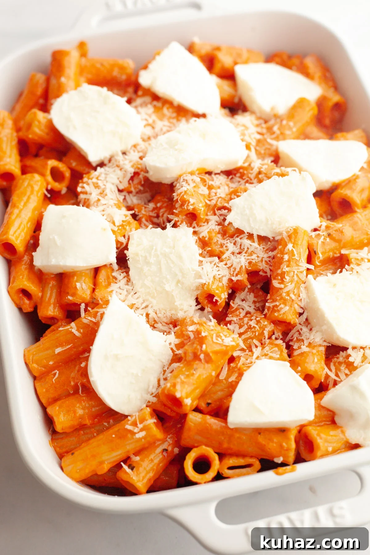 Creamy Baked Pasta with Vodka-Style Sauce, Alcohol-Free 9 Vodka pasta in a white baking dish topped with mozzarella slices and parmesan.
